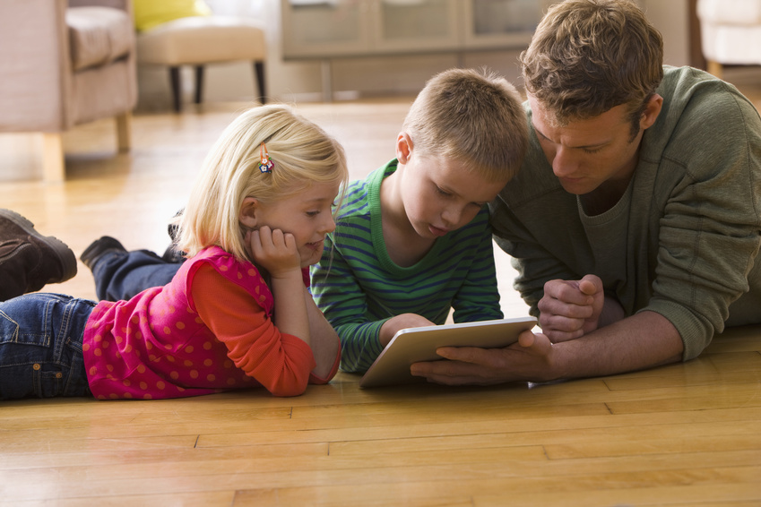 Caucasian father and children using digital tablet