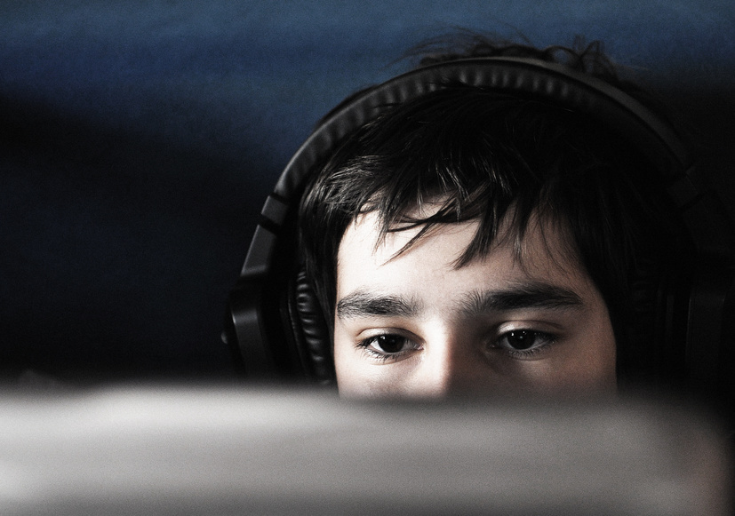 Teen boy with headphones and laptop